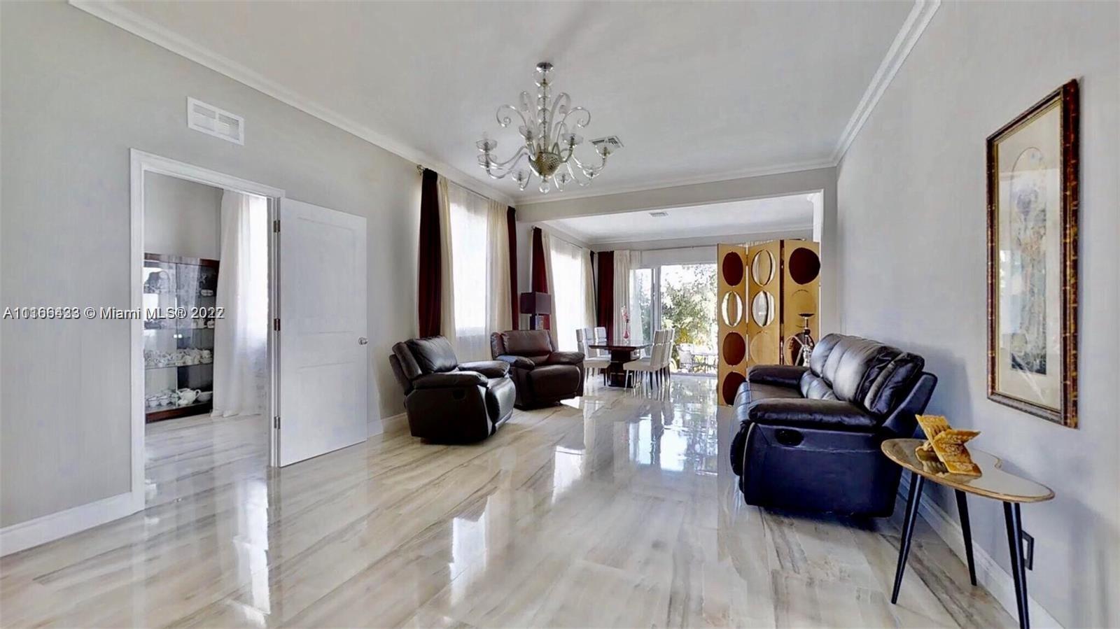 9033 Byron Avenue Surfside, FL 33154 - Photo 15 of 25 a living room with furniture a chandelier and a wooden floor