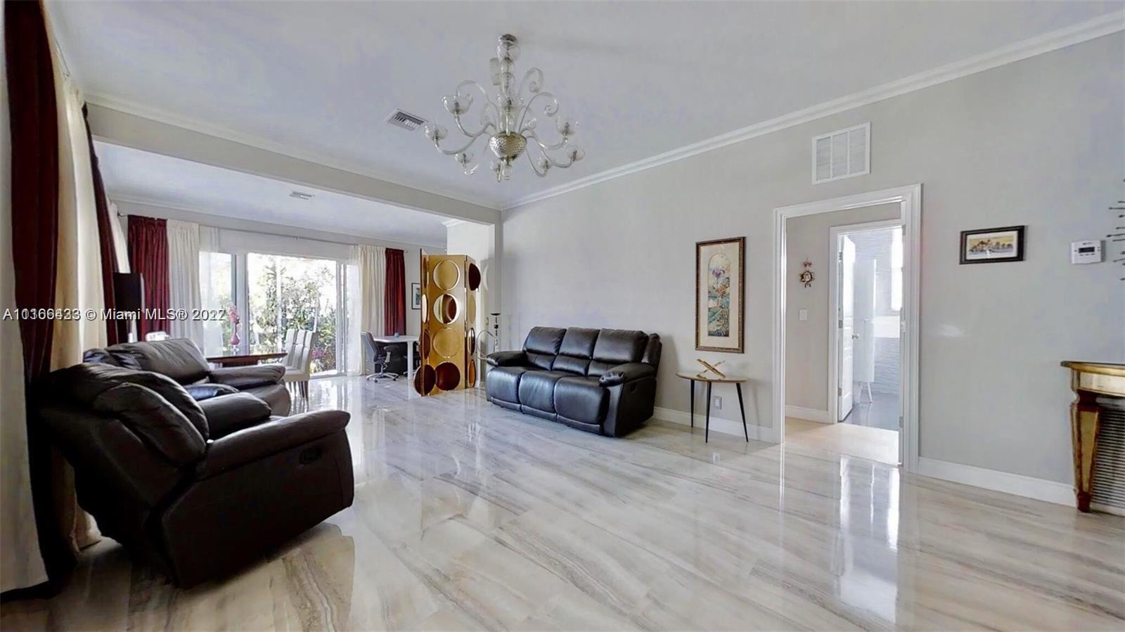 9033 Byron Avenue Surfside, FL 33154 - Photo 16 of 25 a living room with furniture and a chandelier