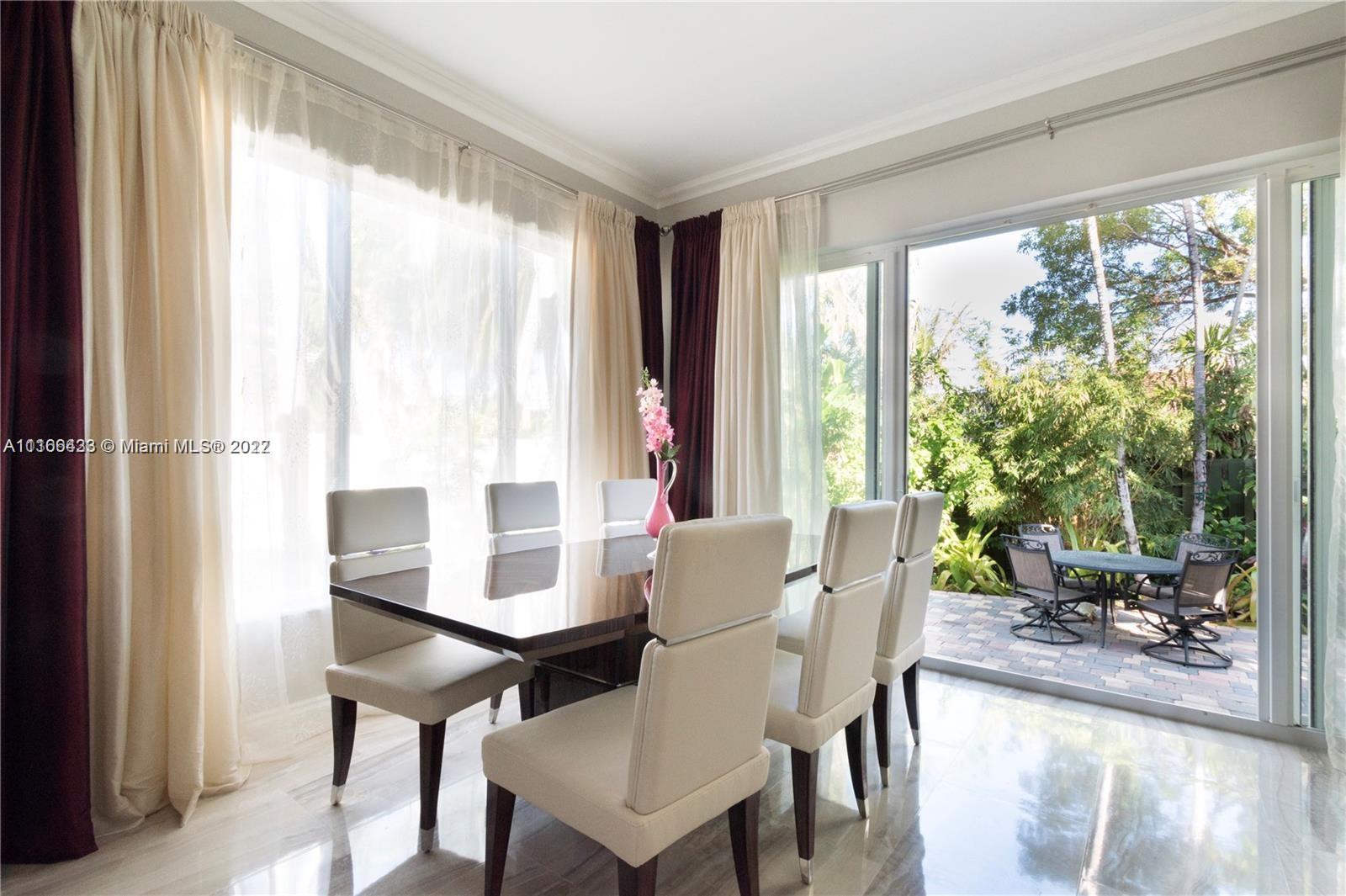 9033 Byron Avenue Surfside, FL 33154 - Photo 19 of 25 a view of a dining room with furniture and a window