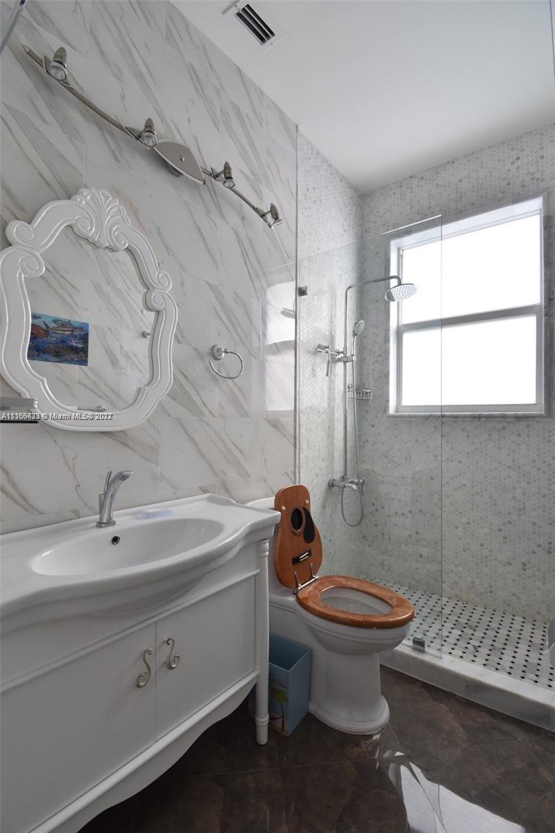 9033 Byron Avenue Surfside, FL 33154 - Photo 25 of 25 a bathroom with a sink a toilet and shower