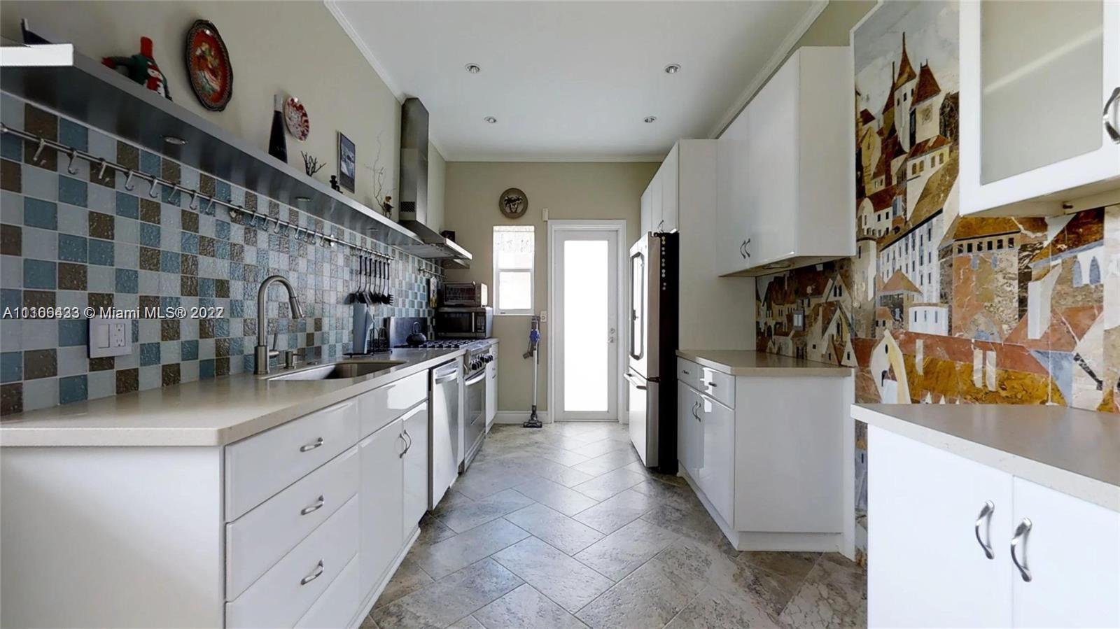 9033 Byron Avenue Surfside, FL 33154 - Photo 9 of 25 a kitchen with stainless steel appliances a sink and a refrigerator