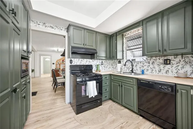 a kitchen with stainless steel appliances granite countertop a stove top oven a sink and dishwasher