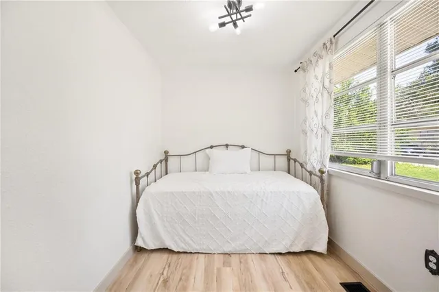 a large bed sitting in a bedroom next to a window