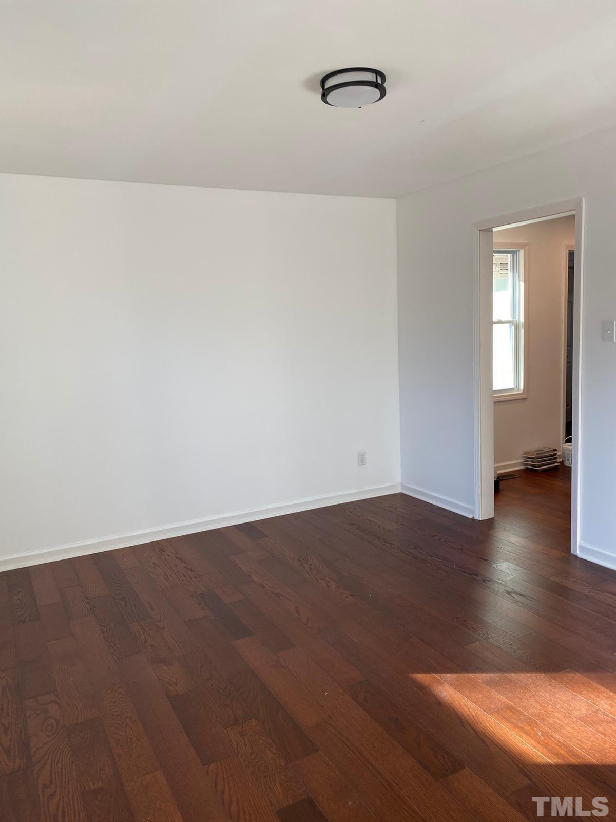 5907 Scalybark Road Durham, NC 27712 - Photo 3 of 3 an empty room with wooden floor and windows