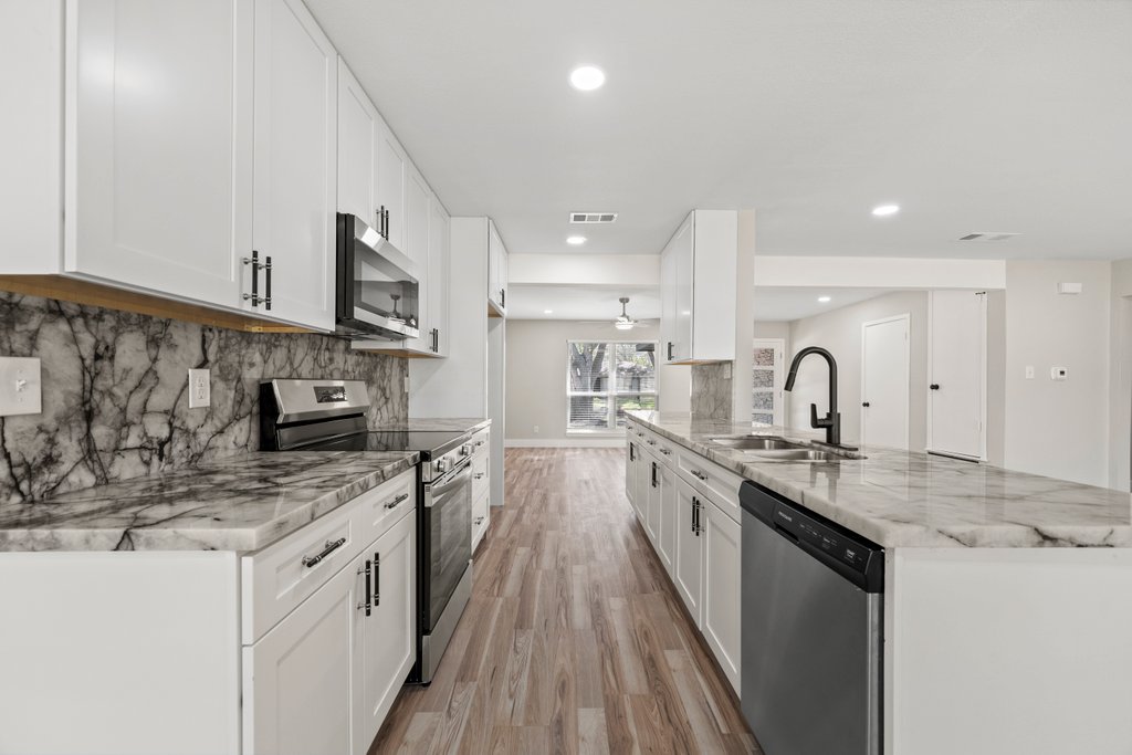 a kitchen with stainless steel appliances granite countertop a sink stove and cabinets