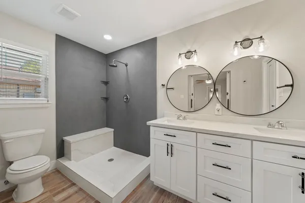 a bathroom with a toilet a sink and a mirror
