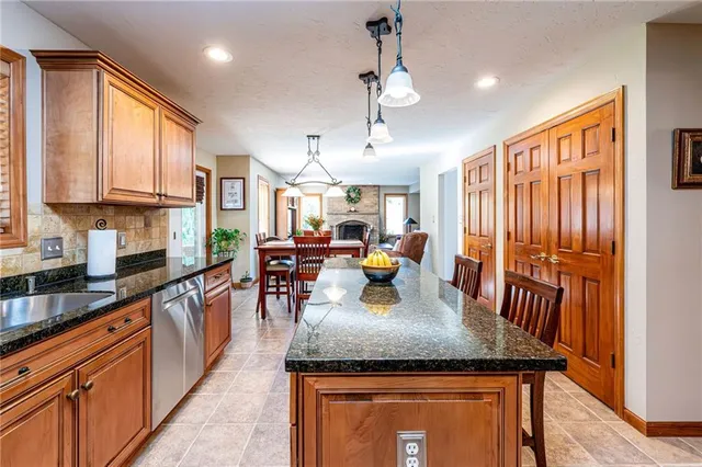 a kitchen with sink refrigerator dining table and chairs