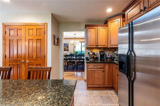 a kitchen with stainless steel appliances granite countertop a refrigerator and a stove top oven