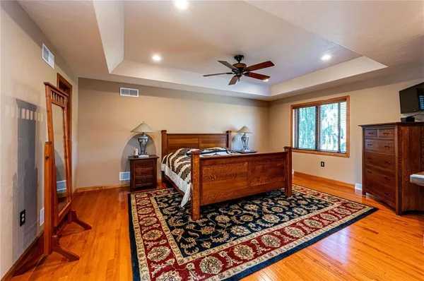 a bedroom with bed and wooden floor