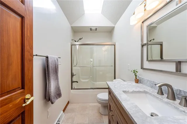 a bathroom with a granite countertop sink toilet and shower