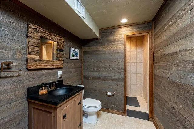 a bathroom with a granite countertop sink and a toilet