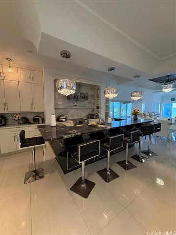 a room with kitchen island stainless steel appliances lots of counter space and a sink
