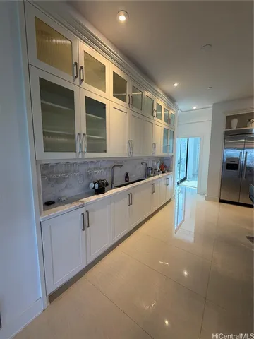 a large white kitchen with stainless steel appliances