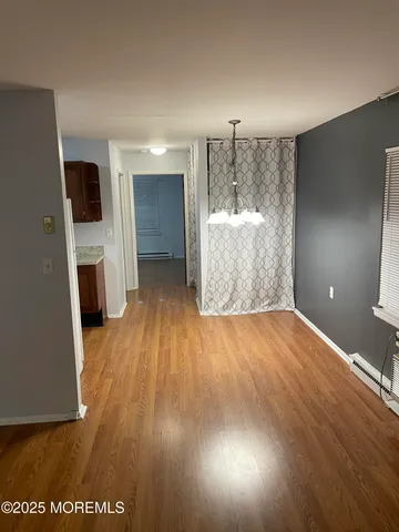 a view of a room with wooden floor and kitchen