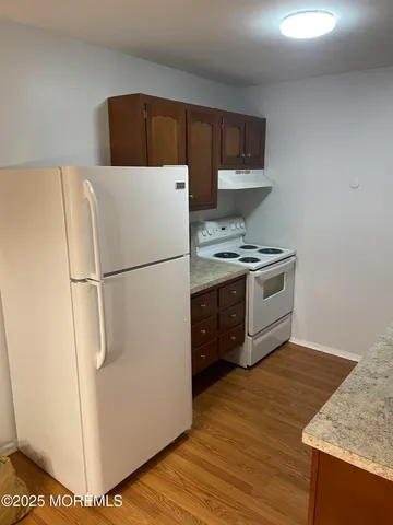 a kitchen with stainless steel appliances granite countertop a refrigerator a stove a sink and a microwave