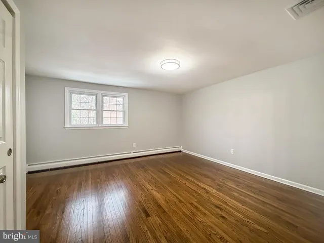 a bedroom with bed and wooden floor