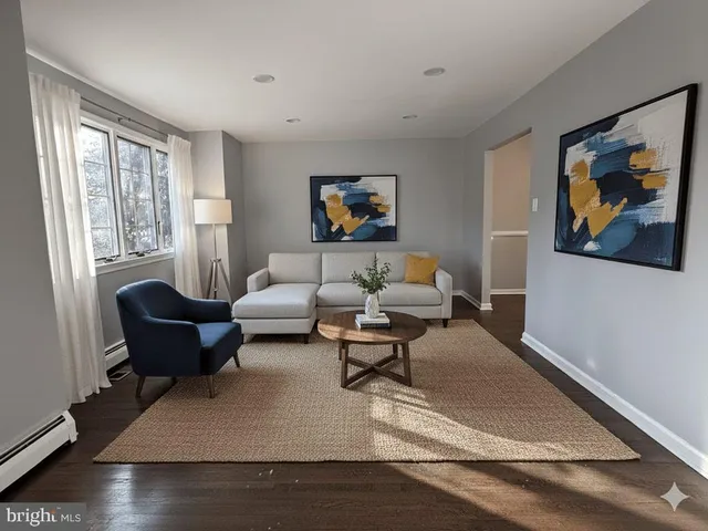 a living room with furniture two window and a painting on the wall