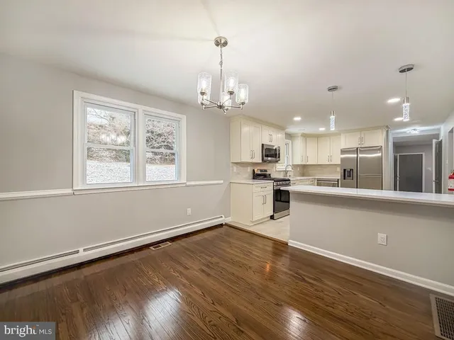 a view of kitchen with granite countertop cabinets wooden floor and a chandelier