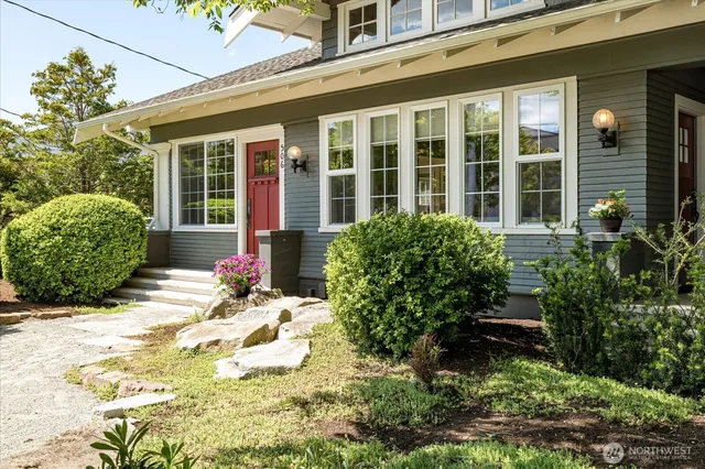 a view of a house with potted plants and a table and chairs