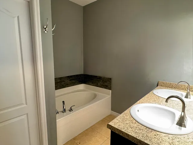a bathroom with a tub sink and mirror