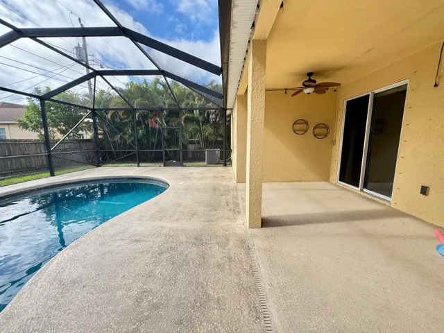 a view of backyard with wooden fence and a bench