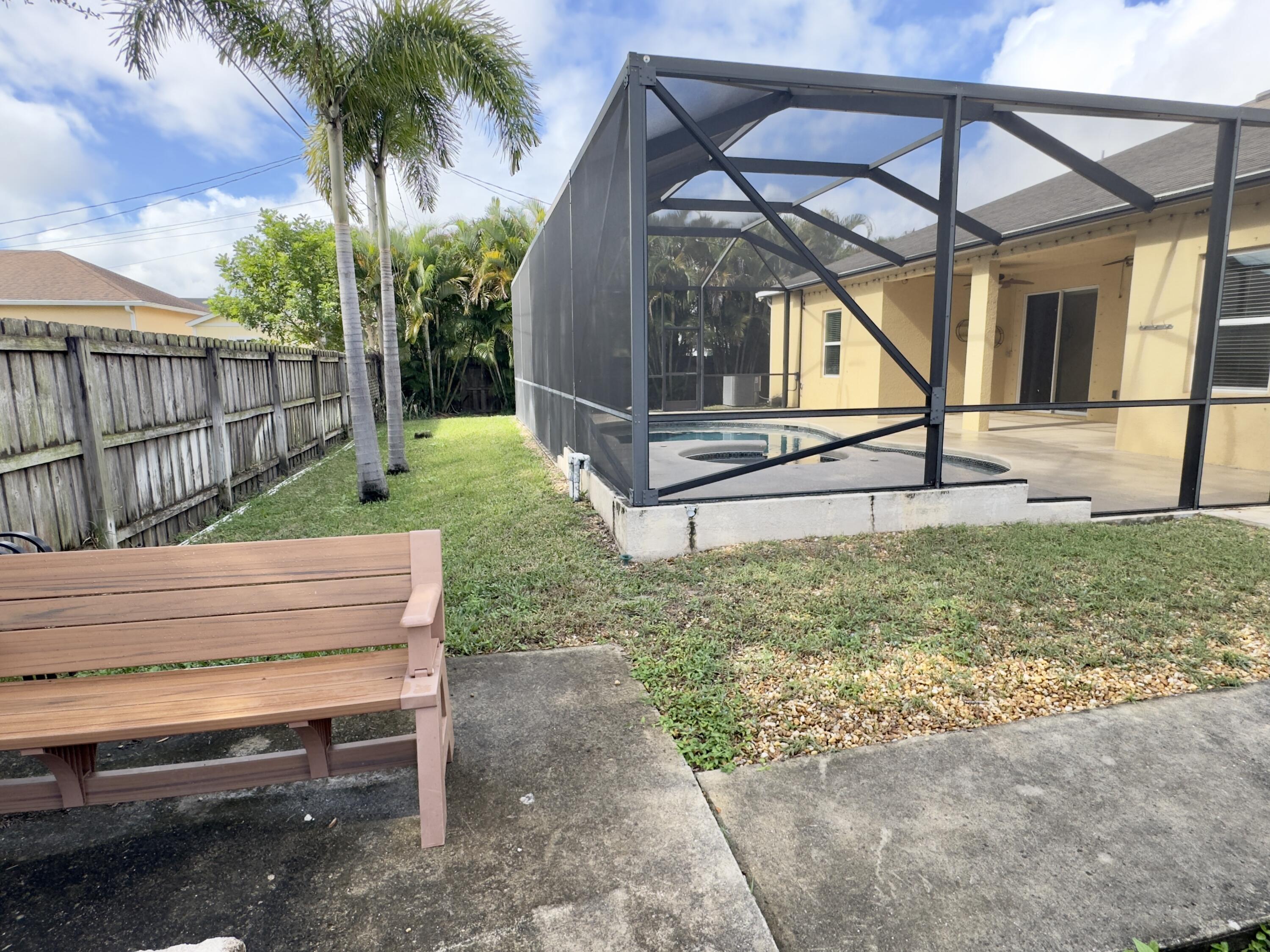 520 Southwest Dailey Avenue Port St. Lucie, FL 34953 - Photo 30 of 34 a view of backyard with wooden fence and a bench