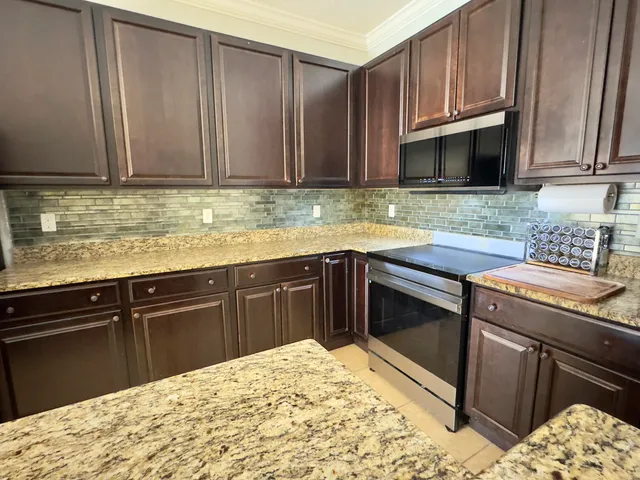 a kitchen with stainless steel appliances granite countertop a sink stove and cabinets