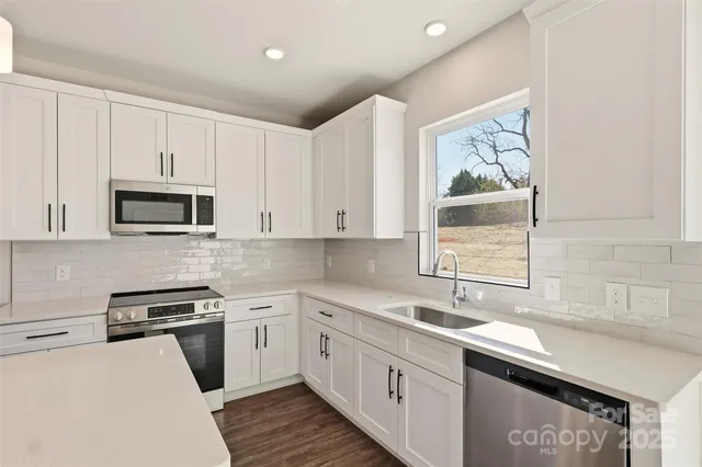 a kitchen with stainless steel appliances granite countertop a sink stove and microwave