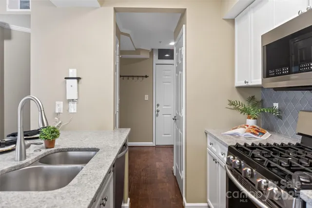 a kitchen with sink a stove and cabinets