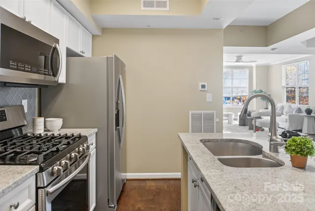 a kitchen with stainless steel appliances granite countertop a sink stove and refrigerator