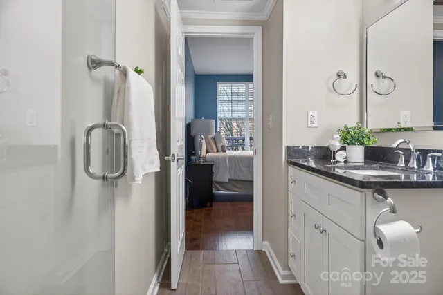 a en suite bathroom with a granite countertop sink and mirror