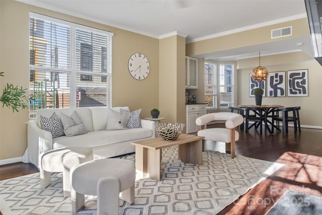 a living room with furniture a large window and dining table
