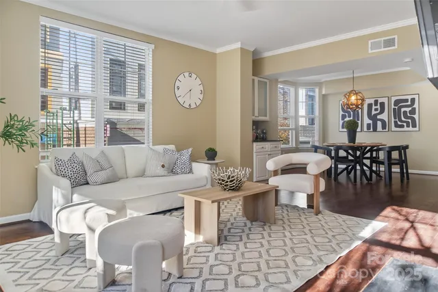 a living room with furniture a large window and dining table