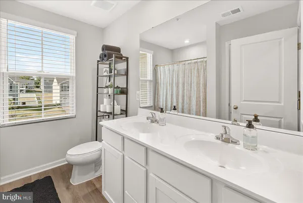 a bathroom with a sink a toilet and a large mirror