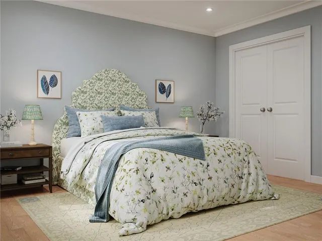 a bedroom with a bed and a lamp on dresser