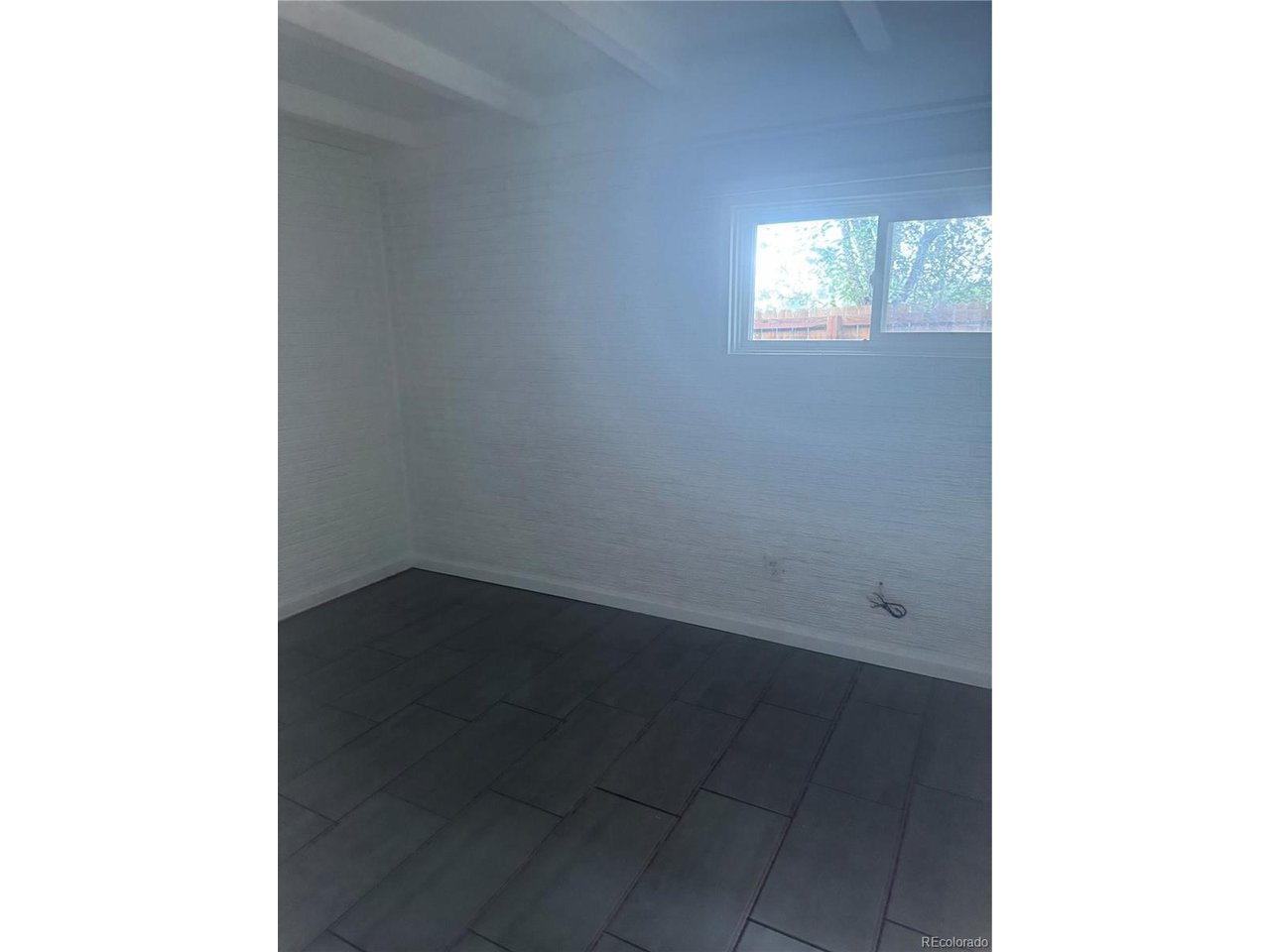 1040 Stuart Street Denver, CO 80204 - Photo 27 of 30 a view of an empty room with wooden floor and a window