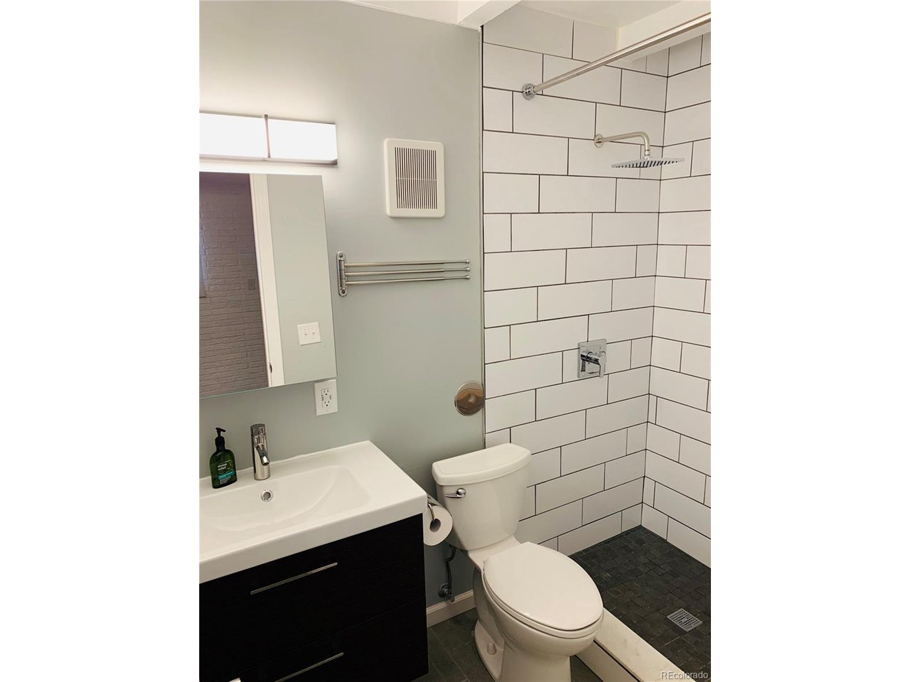 1040 Stuart Street Denver, CO 80204 - Photo 4 of 30 a bathroom with a toilet a sink and mirror