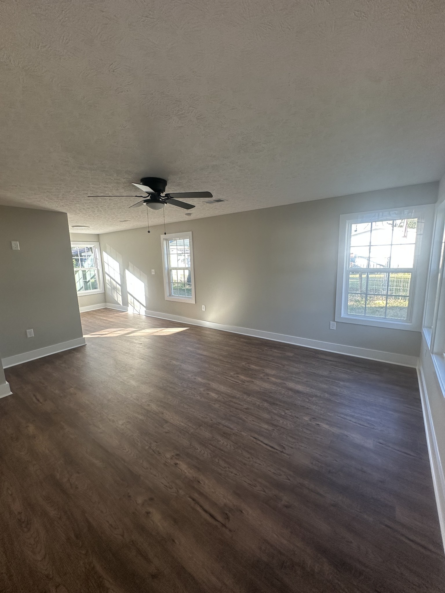 509 Brakefield Street Cowan, TN 37318 - Photo 6 of 19 an empty room with wooden floor and windows