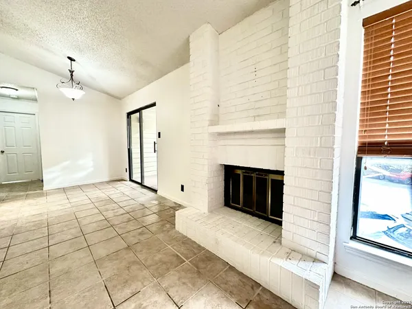 a view of a livingroom with a fireplace and window