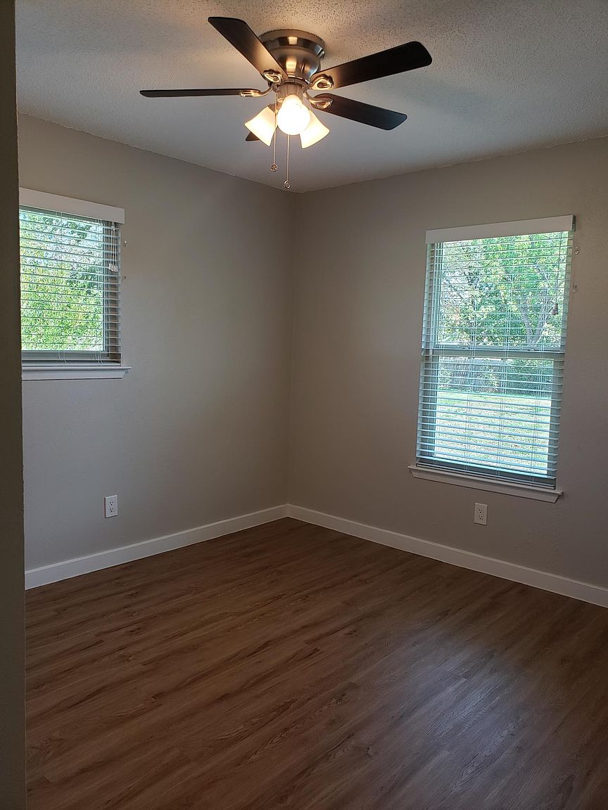 802 Ranch Road, Unit A Georgetown, TX 78628 - Photo 9 of 11 A well-lit room featuring rich wood flooring and a classic ceiling fan for comfort.