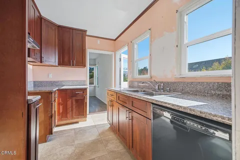 a kitchen with stainless steel appliances granite countertop a sink stove and cabinets