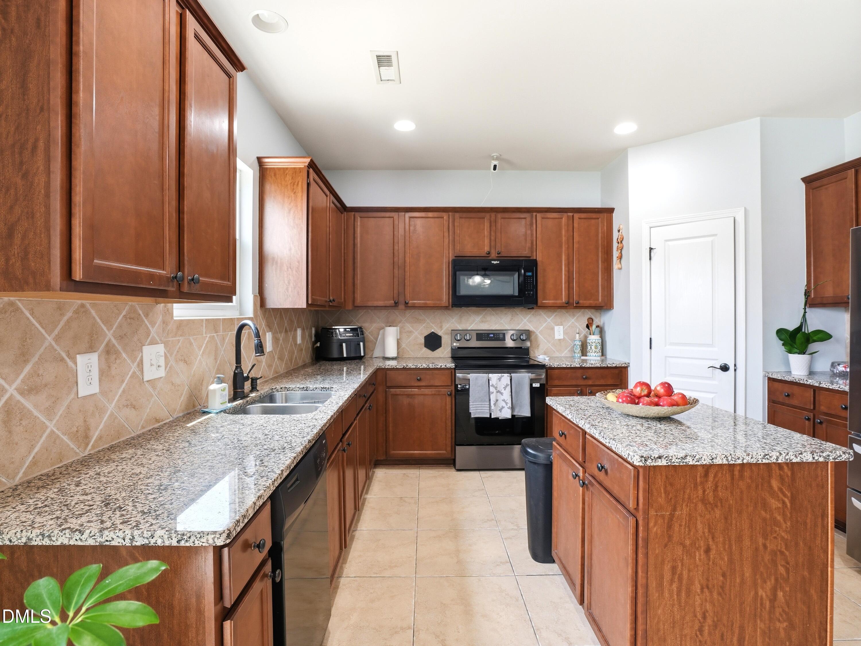 8128 Hovingham Way Raleigh, NC 27616 - Photo 3 of 40 a kitchen with granite countertop a sink and a stove