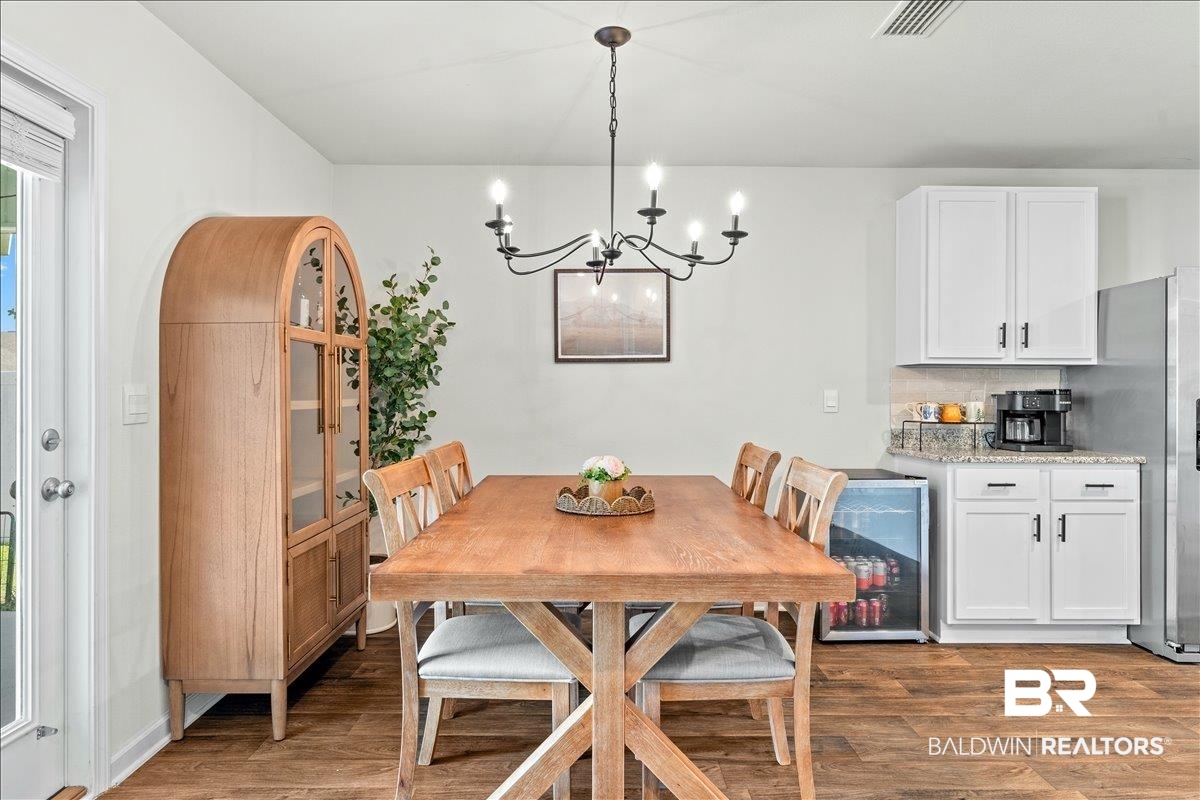 23641 Unbridled Loop Daphne, AL 36526 - Photo 15 of 40 Dining area featuring wood-finish flooring and a multi-bulb chandelier