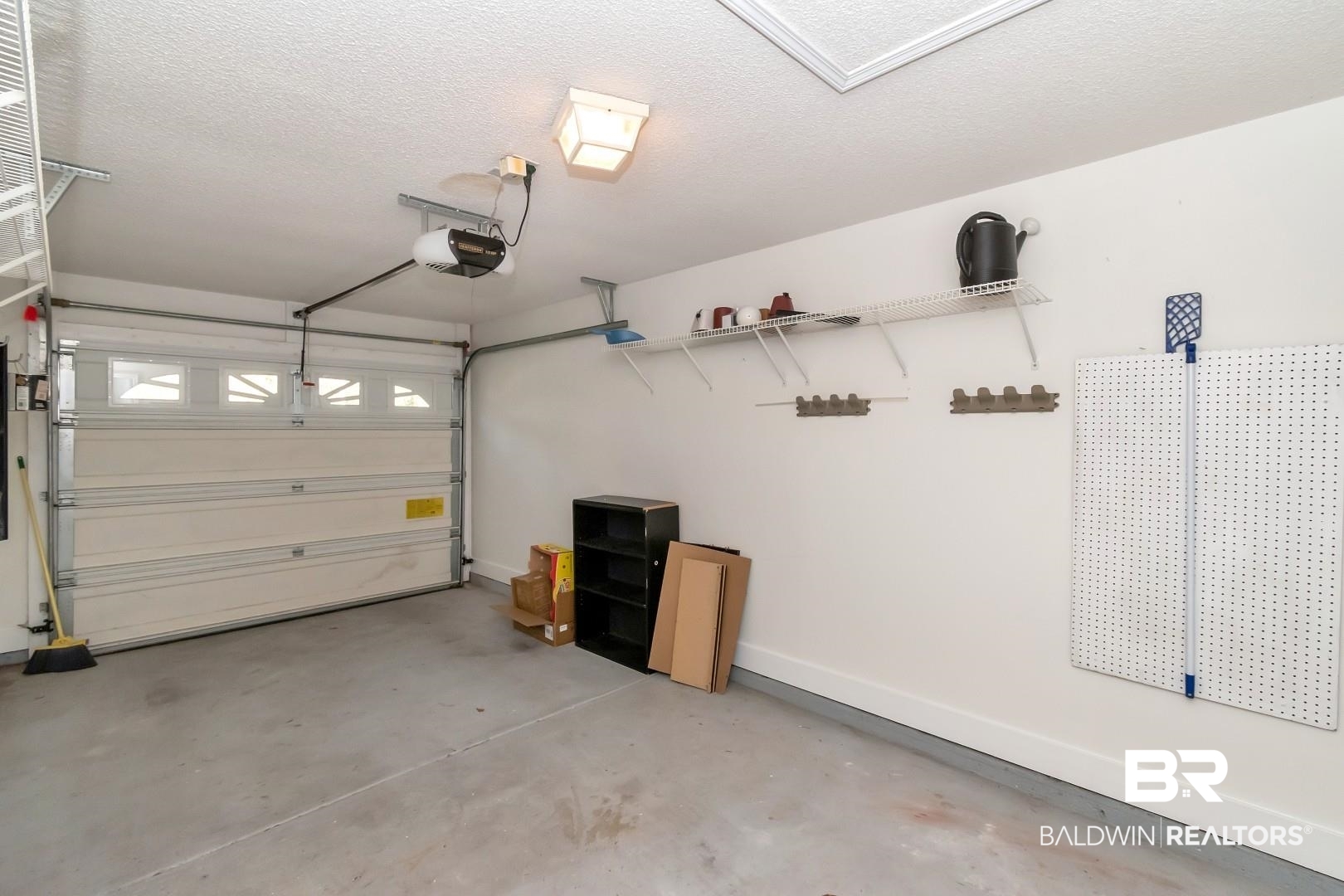 672 Spring Lake Drive East Mobile, AL 36695 - Photo 8 of 26 Garage featuring a garage door opener and baseboards
