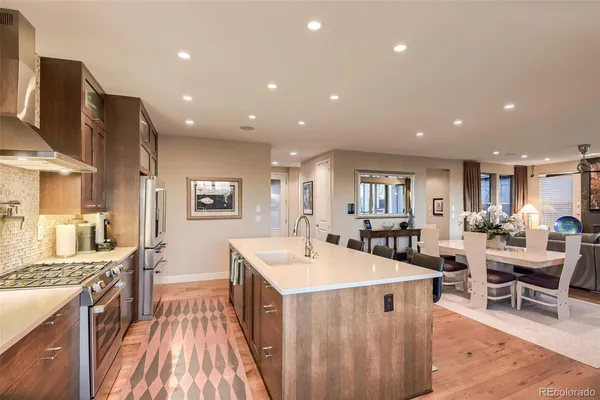 a kitchen with stainless steel appliances granite countertop a table chairs and a refrigerator