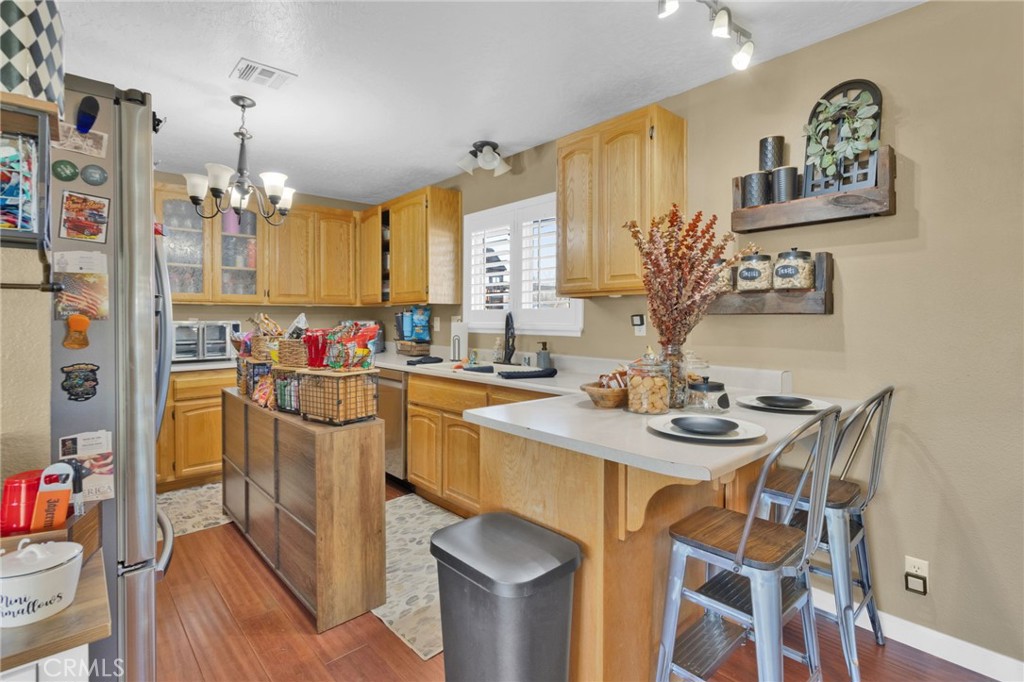21940 Carlisle Road Apple Valley, CA 92307 - Photo 11 of 32 a kitchen with a sink stove and chairs