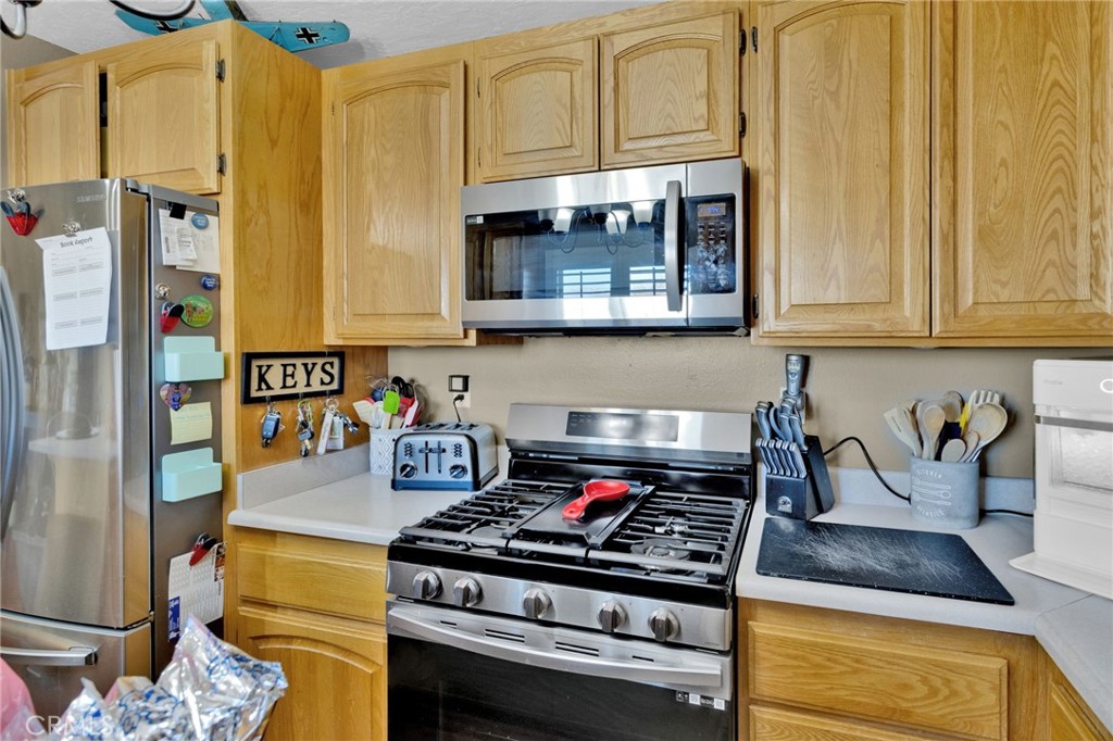 21940 Carlisle Road Apple Valley, CA 92307 - Photo 13 of 32 a kitchen with stainless steel appliances granite countertop a stove and a microwave