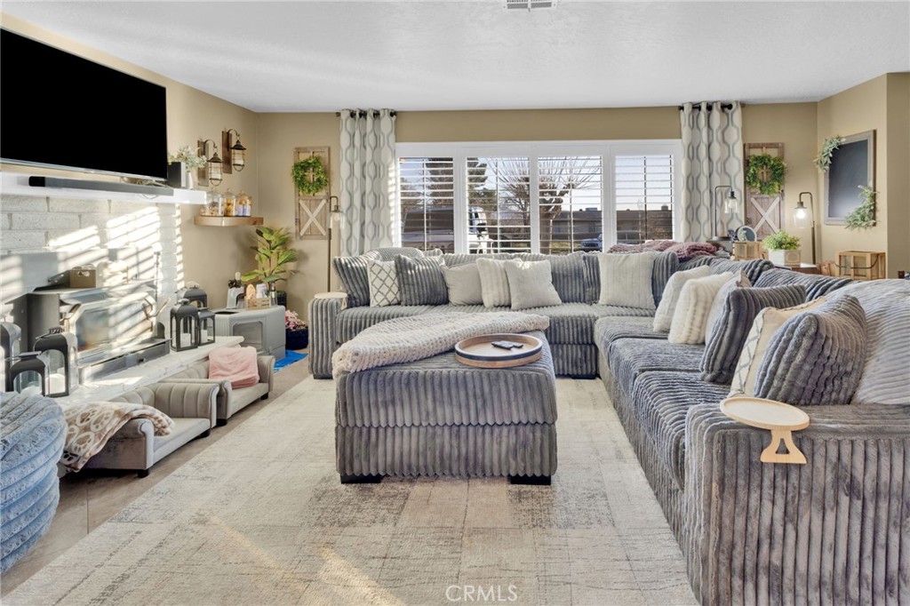 21940 Carlisle Road Apple Valley, CA 92307 - Photo 7 of 32 a living room with furniture a flat screen tv and a large window