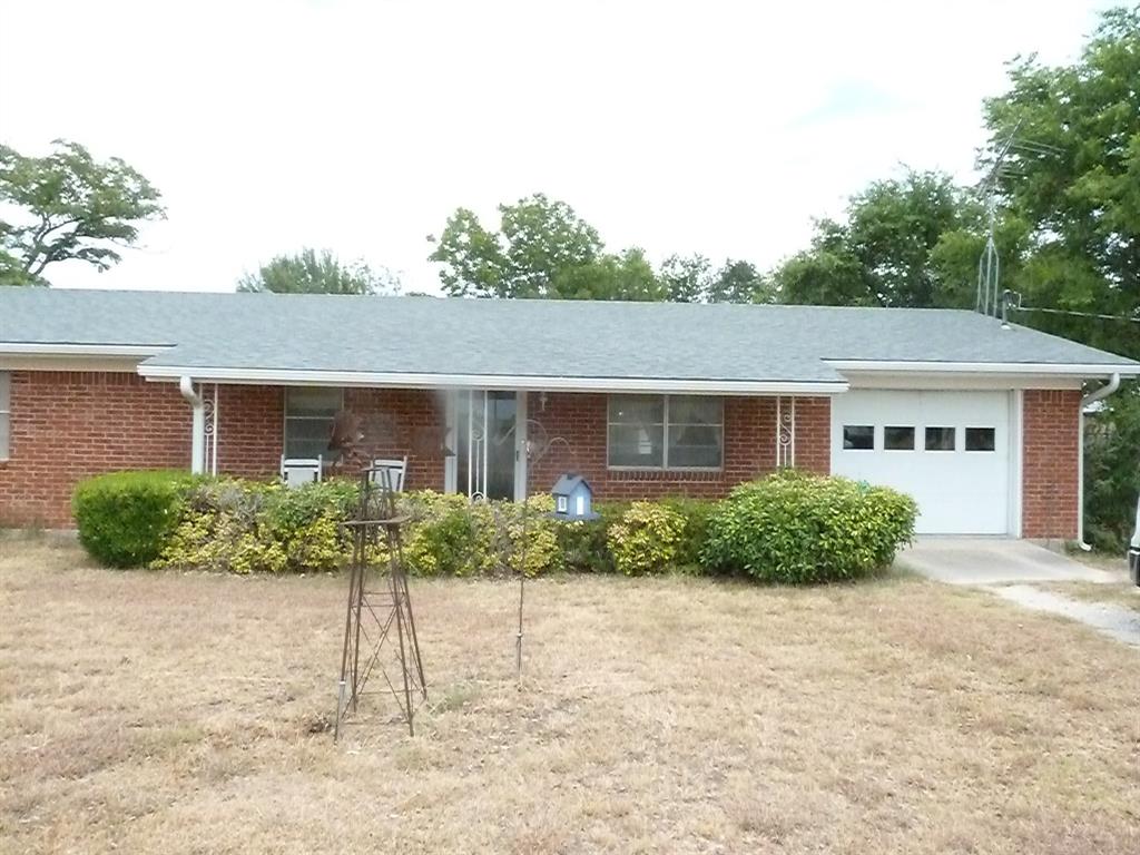 a front view of a house with a yard and potted plants