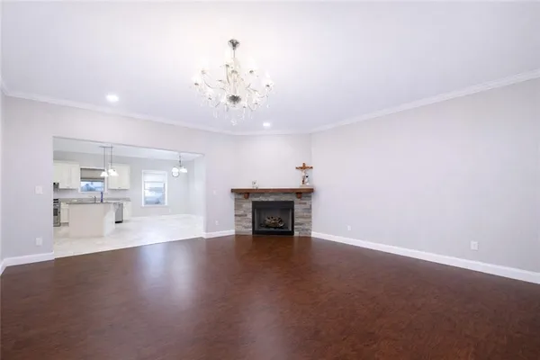 a view of a livingroom with fireplace wooden floor and a chandelier
